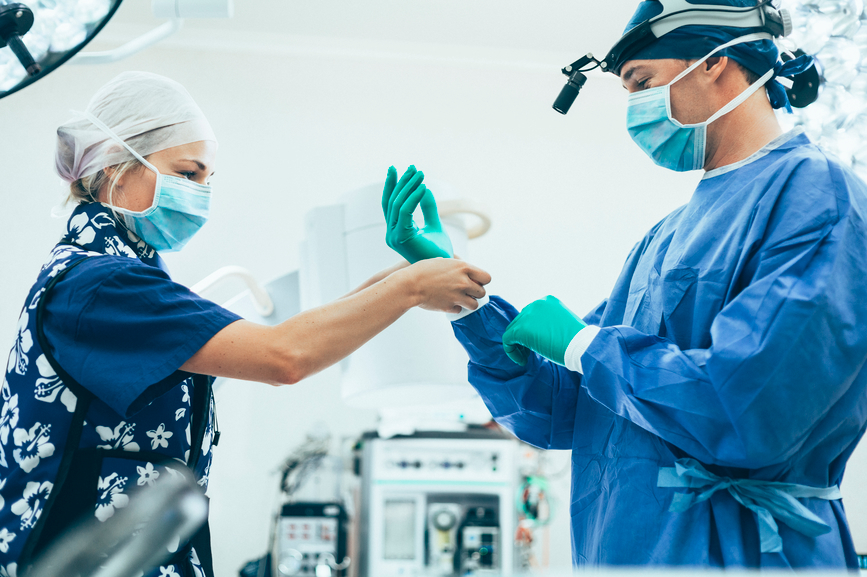 Surgeon and nurse in operating theatre waring PPE Surgeon and nurse in operating theatre waring PPE